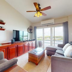 Sunny waterfront villa with outdoor pool, balcony, & AC