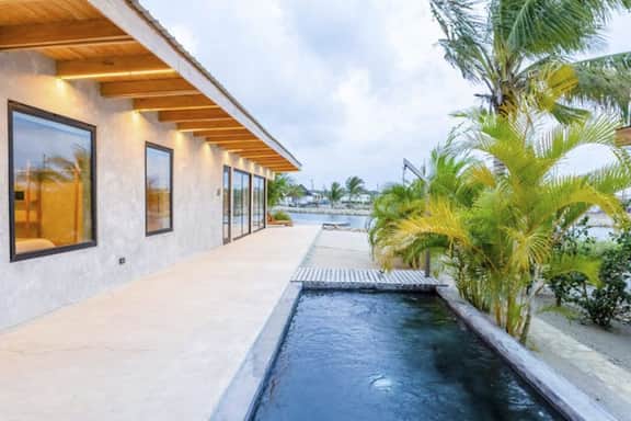 Stylish waterfront villa with pool, lush views & floor-to-ceiling windows - Image 2