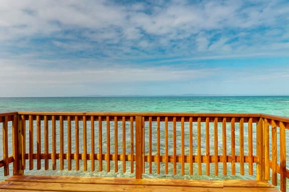 Overwater cabin with oceanfront deck, island kitchen & sea breeze views - Image 1